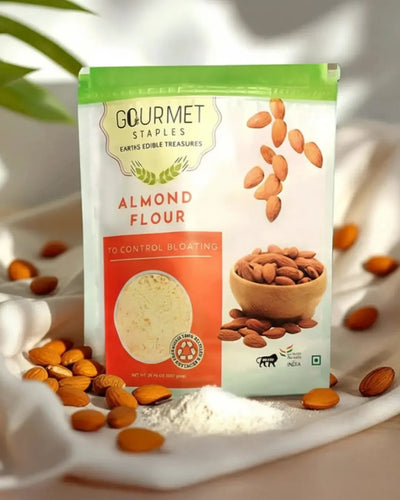 Almond flour packet surrounded by raw almonds and flour on white cloth in natural light